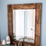 DIY Rustic Bathroom Mirror from an ornate thrift store mirror. Learn how to remove the glass and create a chunky wood framed mirror.